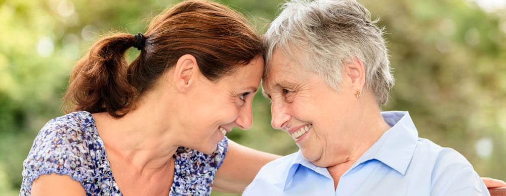 Mother and daughter smiling and embracing